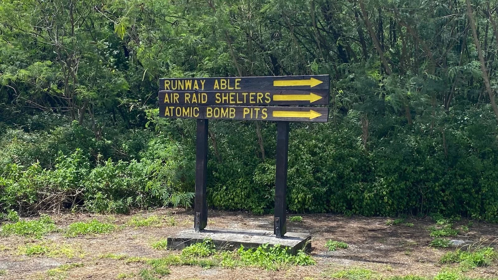 Historic sign on Tinian pointing to Runway Able, air raid shelters, and the Atomic Bomb Pits. From these runways the B-29 Superfortress Enola Gay departed for the atomic bombing of Hiroshima on August 6, 1945.