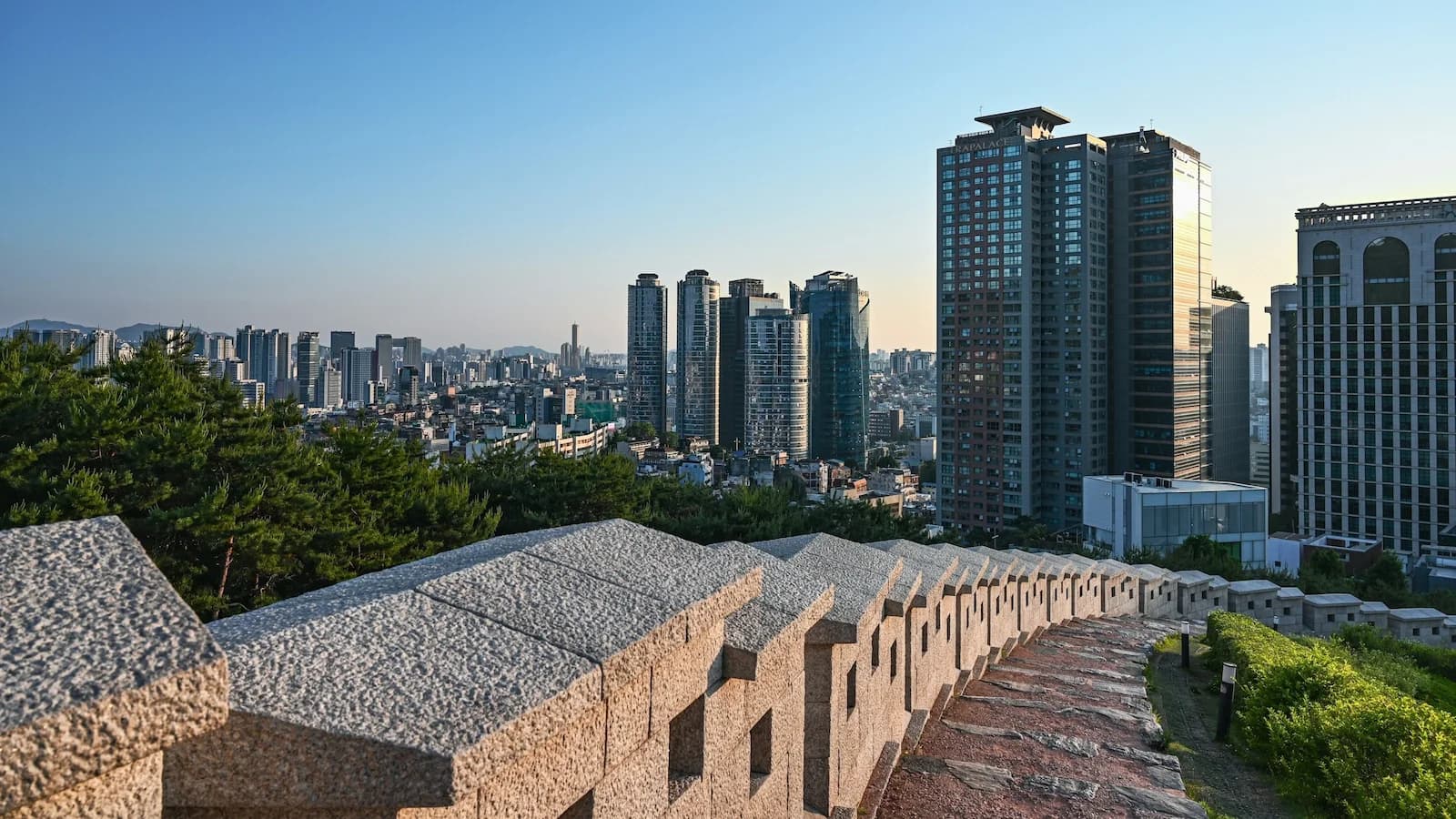 Seoul City Wall with modern skyscrapers in the background, illustrating the striking contrast between ancient fortifications and today’s dynamic capital on Essential History Expeditions’ Korea tour.