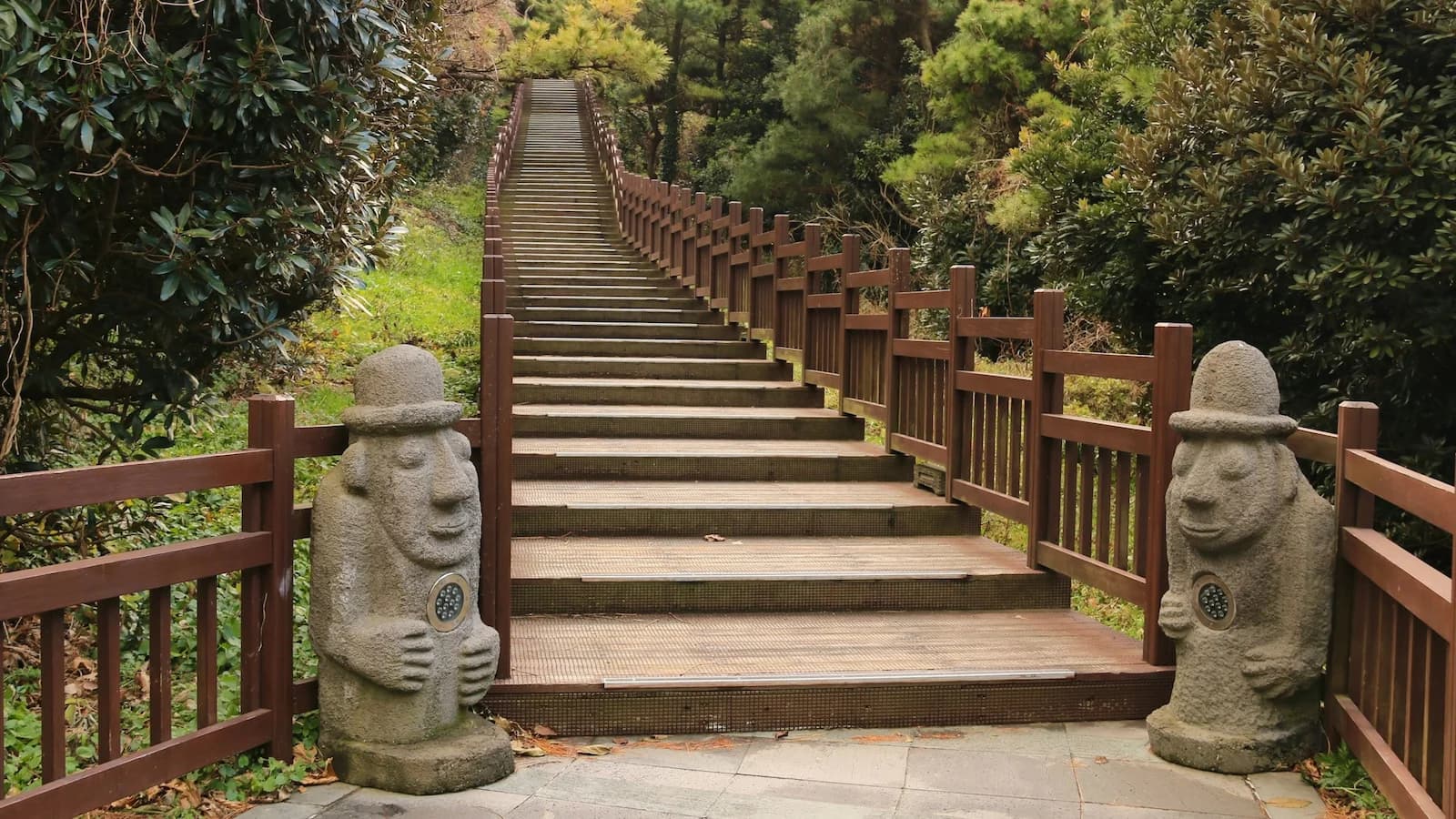 Stone grandfather statues (Harubang) flanking the staircase entrance to Hallasan Mountain, the highest peak in South Korea and a UNESCO World Natural Heritage site on Essential History Expeditions’ Jeju extension.