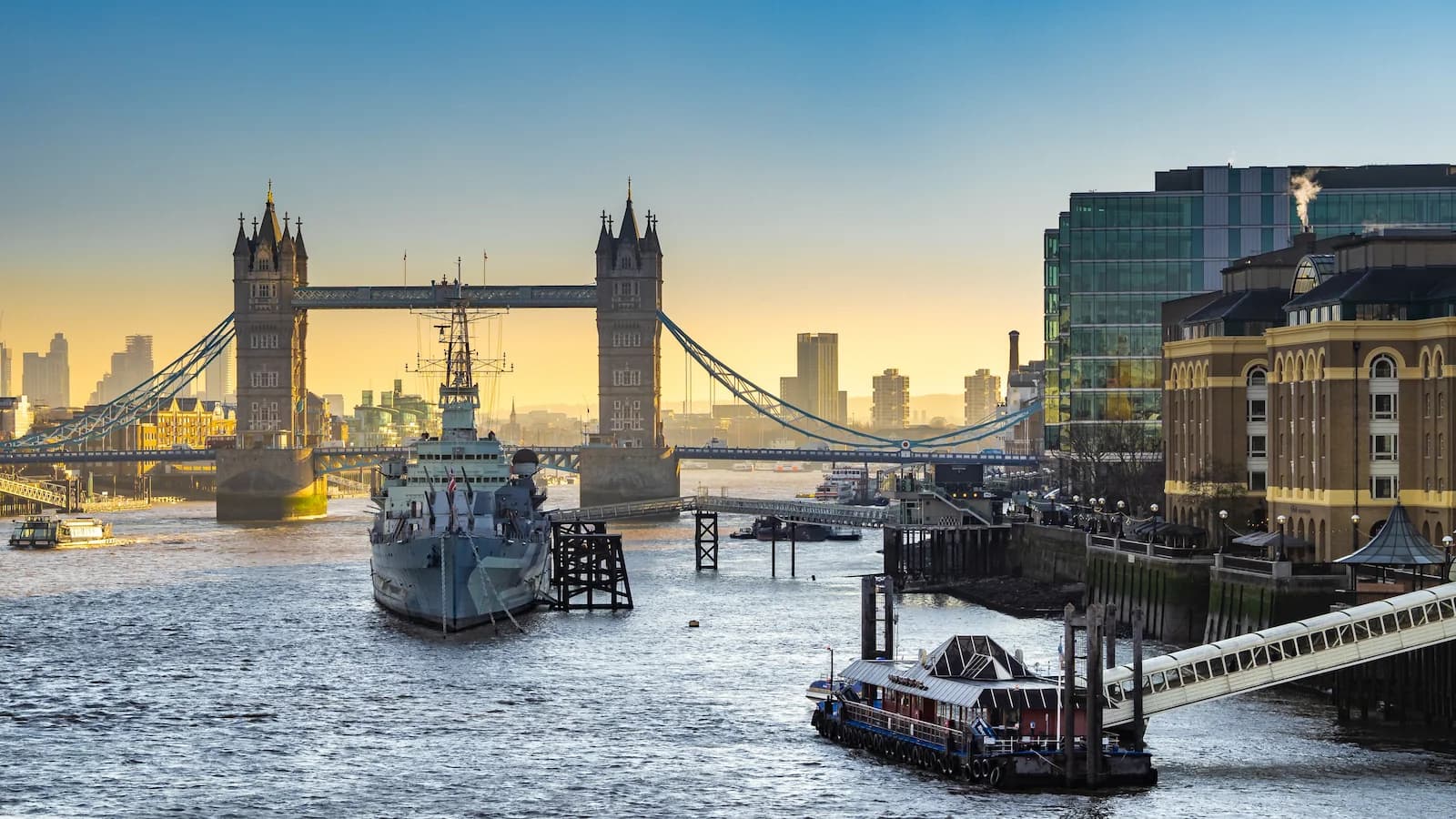View of the HMS Belfast on the River Thames in London, with the Tower Bridge in the background.
