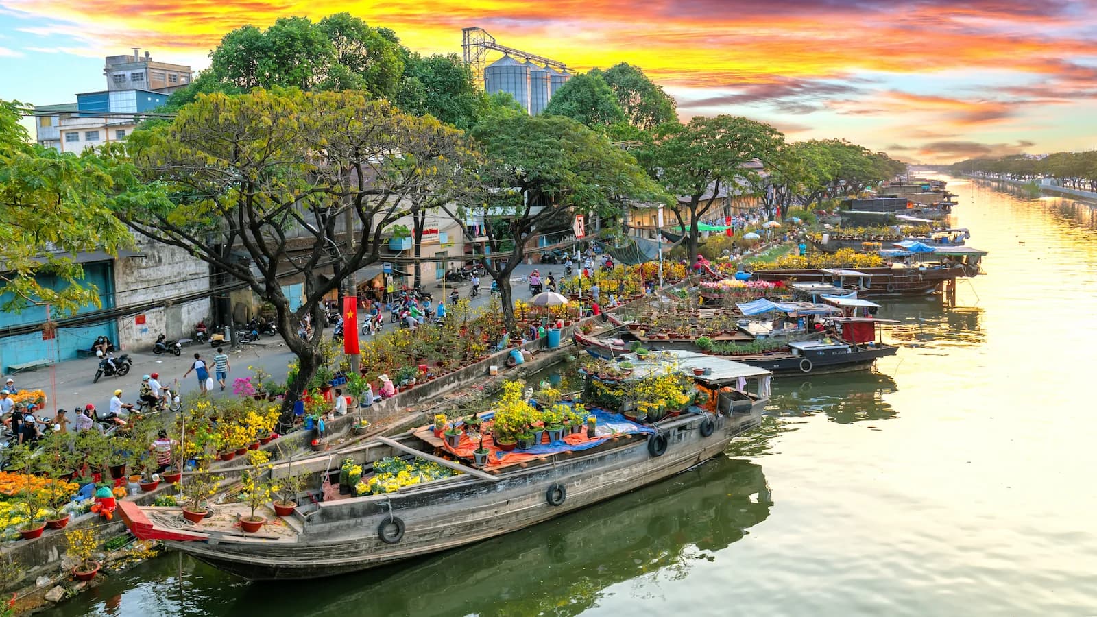 Colorful flower boats on the Saigon River at dusk. A vibrant scene from daily life in Ho Chi Minh City experienced during our Essential Vietnam: History & Culture trip.