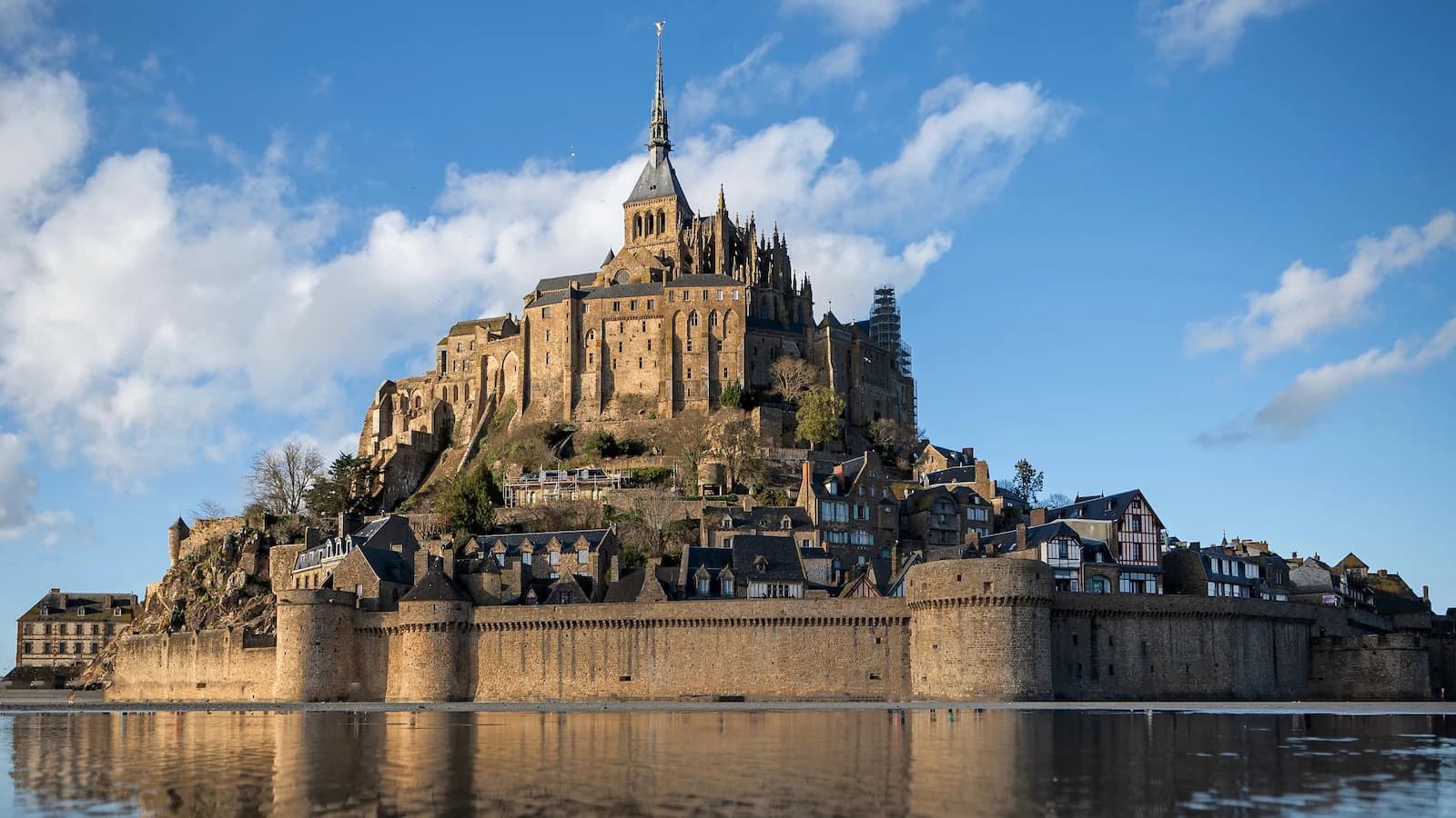 Water reflects the image of Mont-Saint-Michel Abbey, a UNESCO World Heritage Site, in Normandy, France.