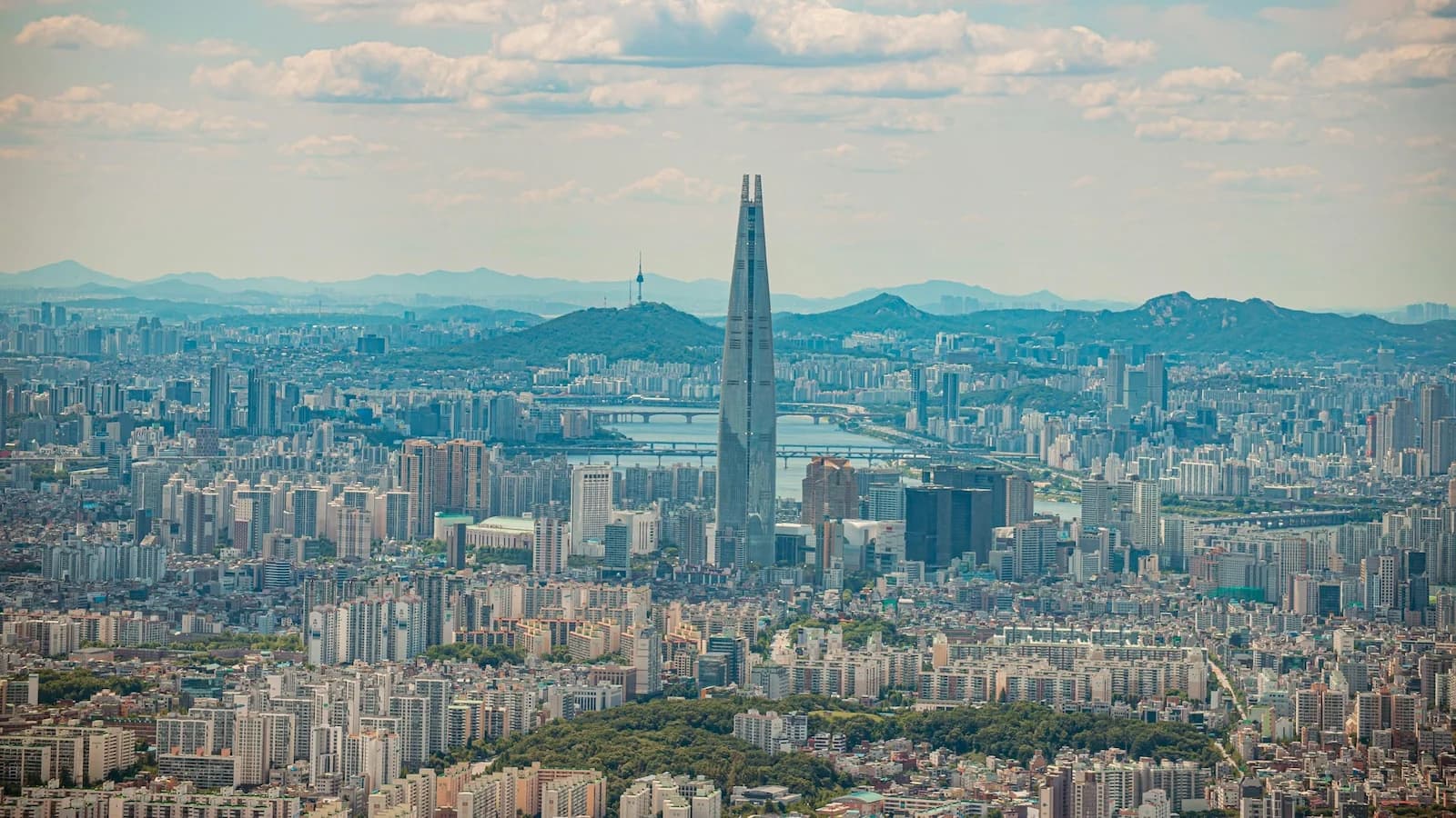 Panoramic Seoul skyline featuring Lotte World Tower and N Seoul Tower, the final stunning view before departing for the optional Jeju extension on Essential History Expeditions’ Korea tour.