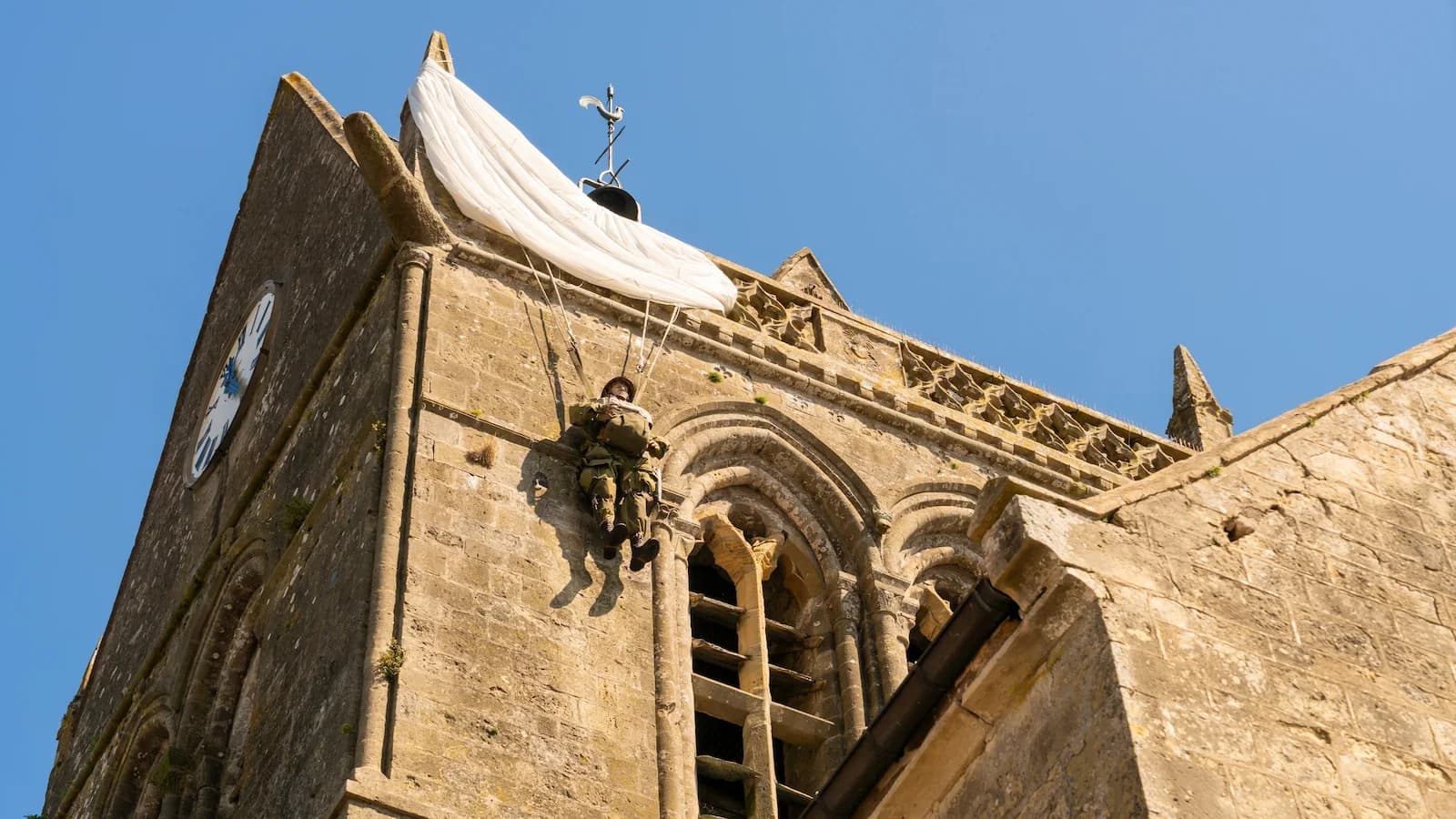 Statue of an American 82nd Airborne paratrooper hanging from the church steeple in Sainte-Mère-Église, commemorating the first French town liberated by U.S. forces on D-Day.