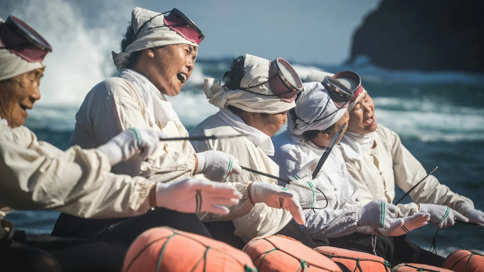 Haenyeo sea women, the legendary female free divers of Jeju Island, harvesting seafood in traditional white uniforms, a unique cultural highlight of Essential History Expeditions’ Jeju extension.