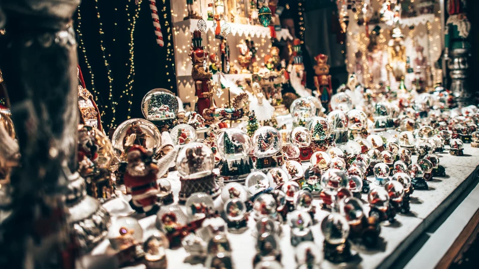 Festive snow globe stand glowing at the Luxembourg City Christmas Market. Guests on our Bulge 85 tour enjoy the region’s magical Christmas markets in December 2029.