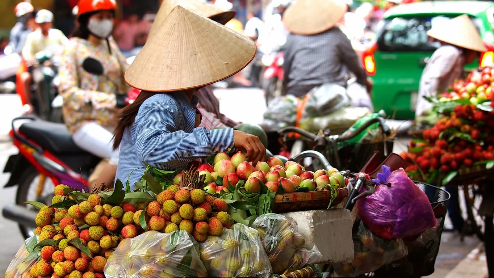 Bustling traditional Vietnamese market filled with fresh produce, flowers, and local goods. A vibrant part of daily life experienced during our Essential Vietnam journey.
