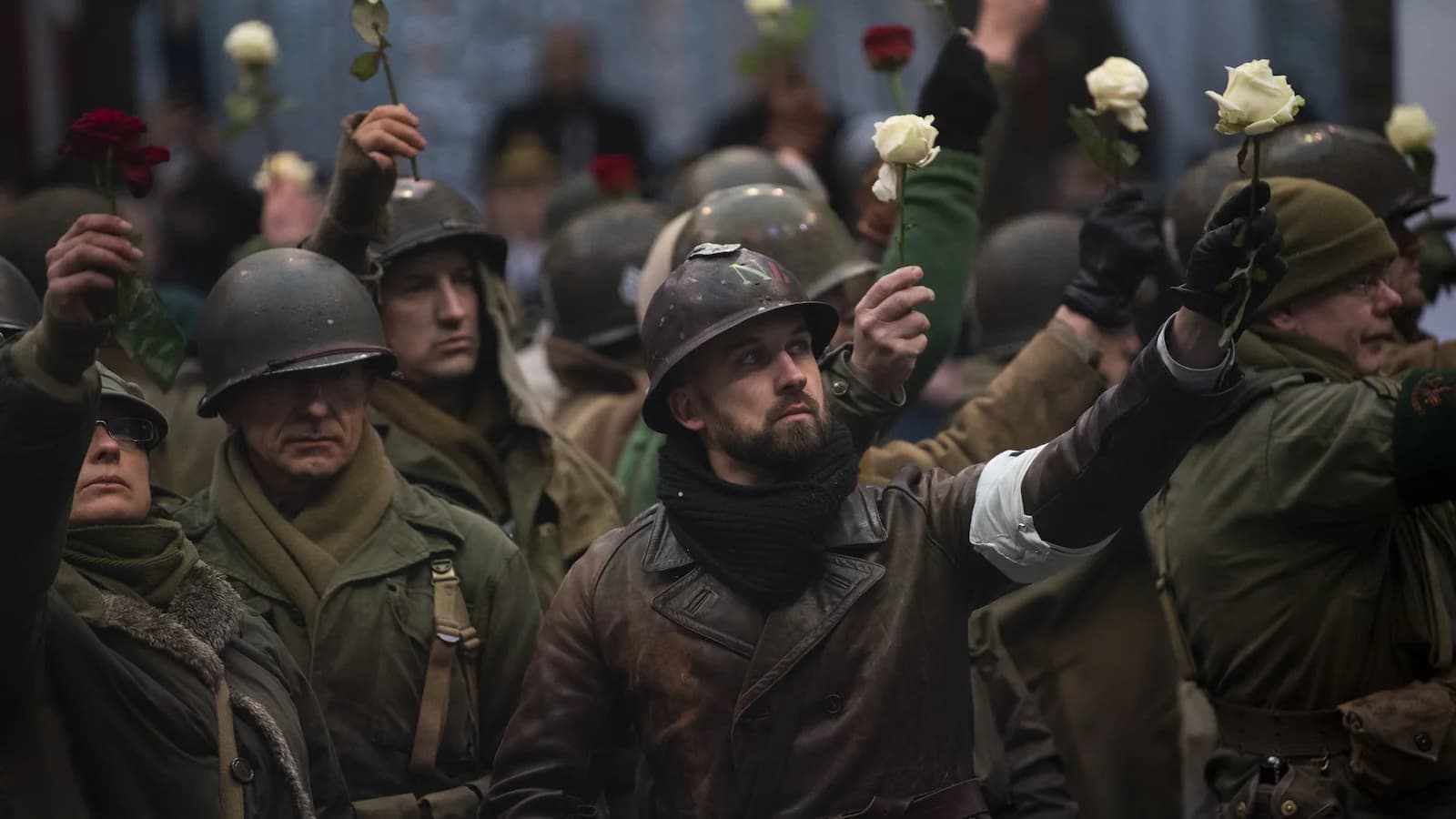 Reenactors in WWII uniforms paying tribute with white roses at a Battle of the Bulge commemoration in Bastogne. Similar moving events will take place during our 85th Anniversary tour in December 2029.