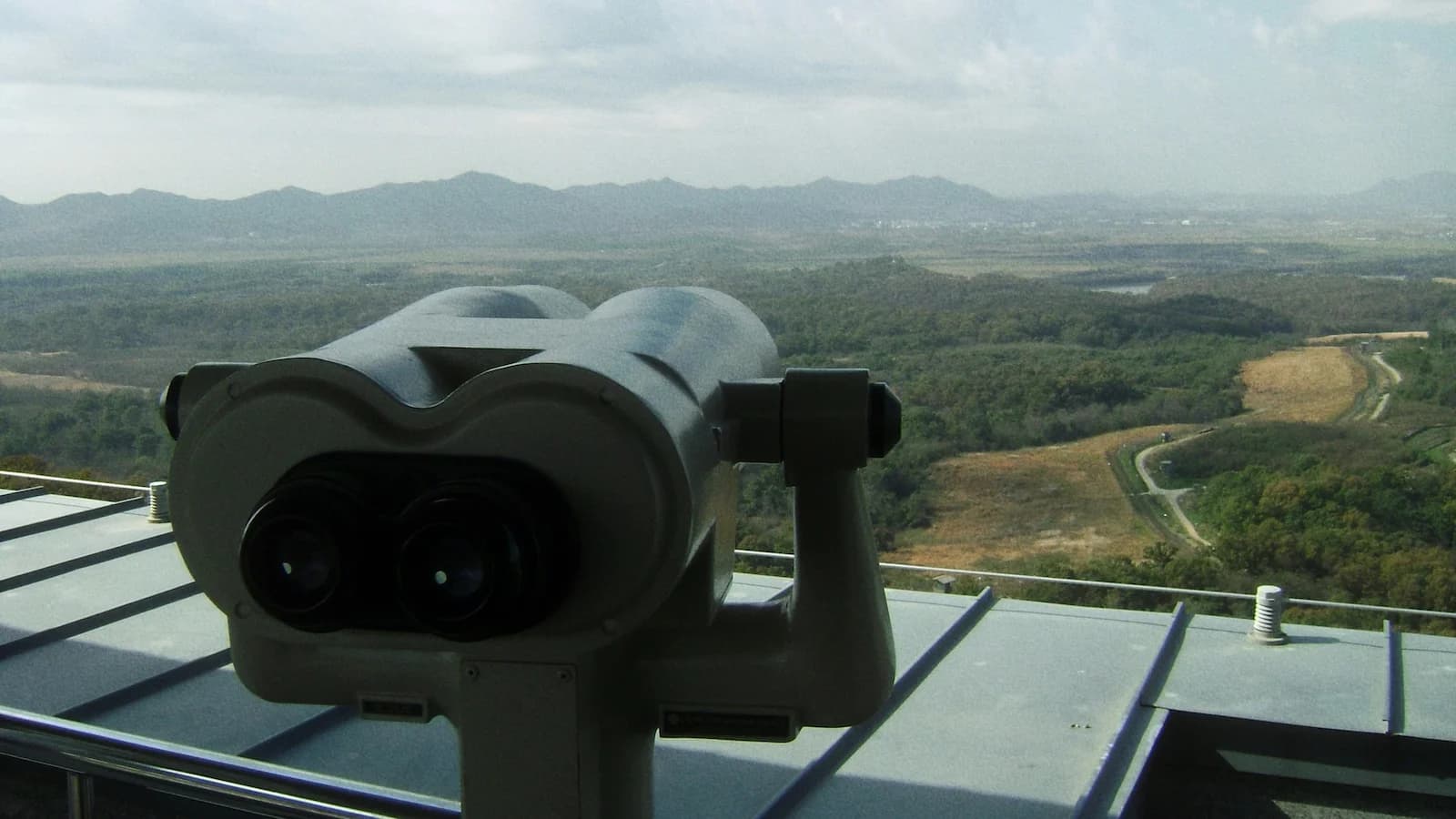 View into North Korea from the DMZ Dora Observatory using binoculars, one of the most powerful moments on Essential History Expeditions’ Korean War and DMZ tour.