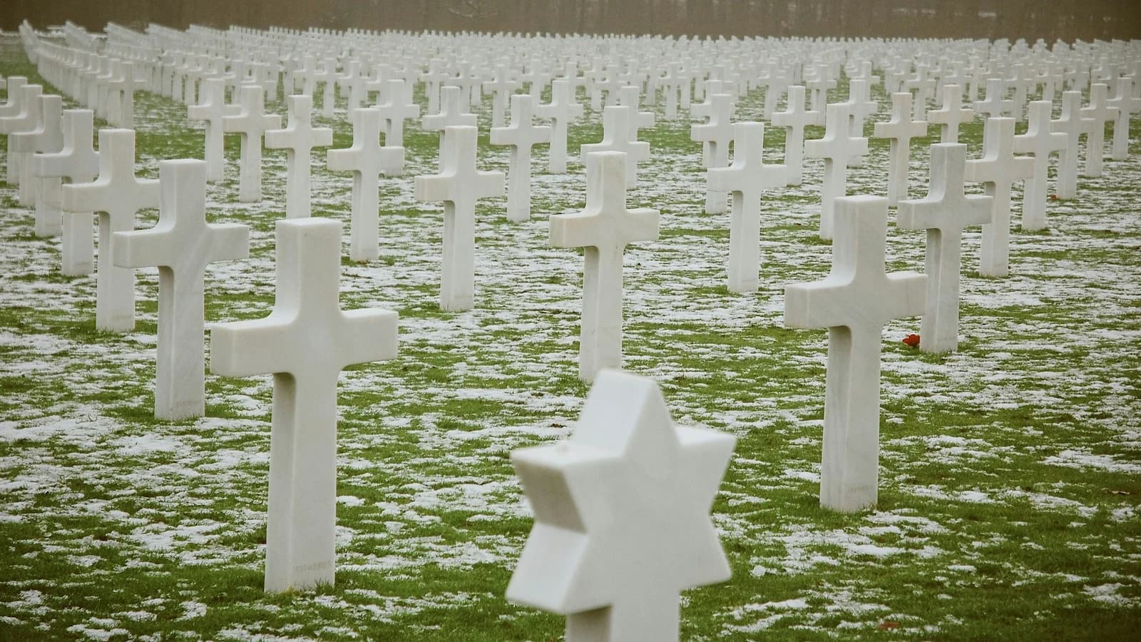 Row upon row of white marble crosses at the Luxembourg American Cemetery under light snow. Final resting place of over 5,000 Americans, including General George S. Patton.