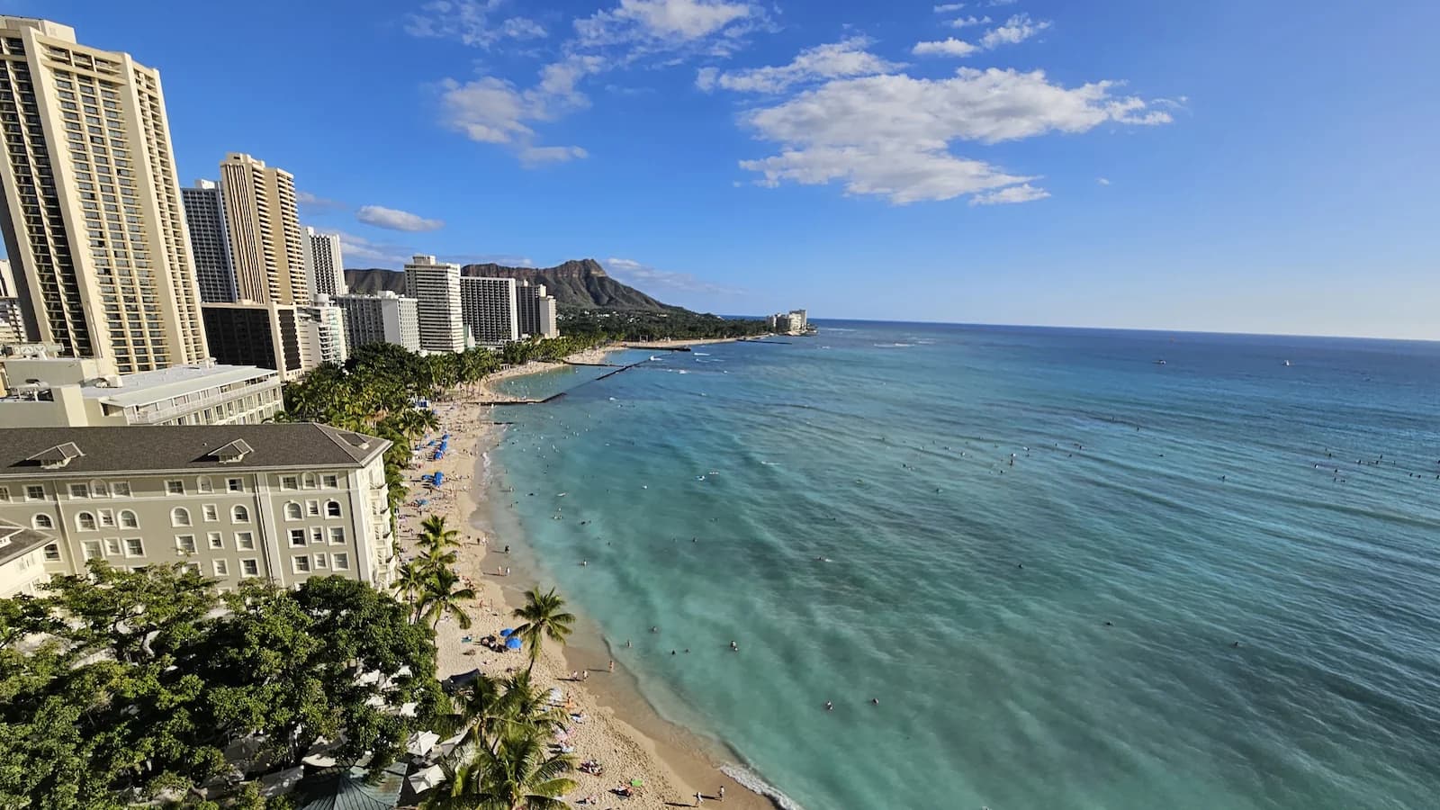 Beautiful daytime view of Waikiki Beach and Diamond Head, the scenic backdrop for Essential History Expeditions’ Pearl Harbor at 85 history and culture tour.