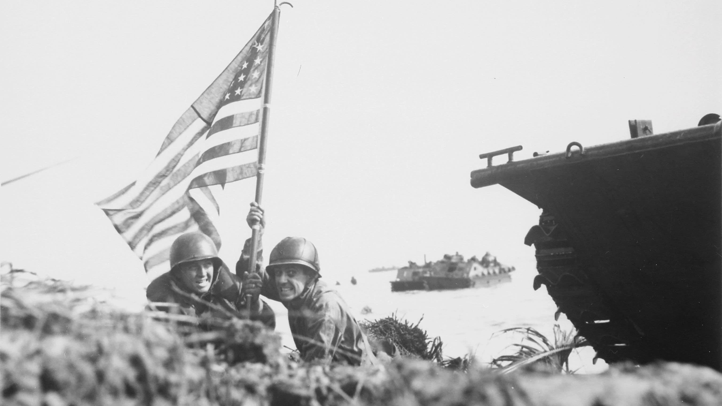 Marines of the 3rd Marine Division raise the first American flag on Guam after recapturing the island from Japanese forces in 1944 representing a powerful symbol of the Pacific War advance toward Japan.