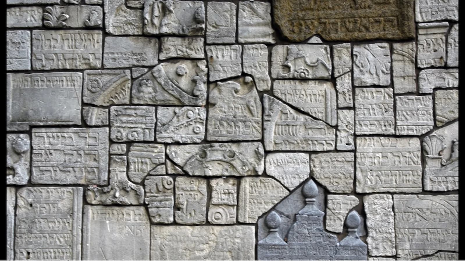 Fragmented memorial wall in Krakow’s Jewish Cemetery, a poignant reminder of the vibrant Jewish community that once thrived in Poland.