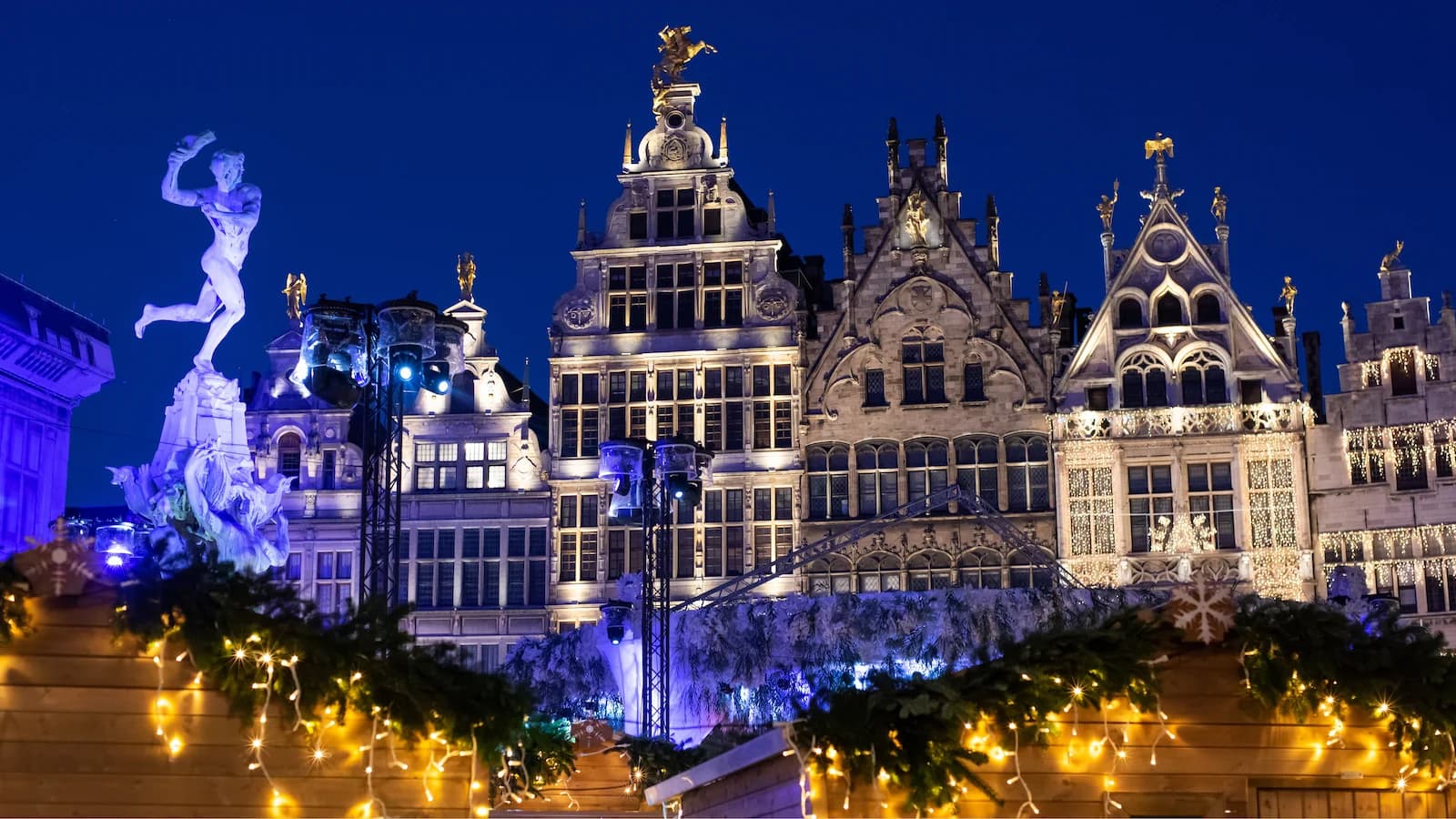 Antwerp Christmas Market at night with illuminated historic guildhalls and festive lights. One of the beautiful Christmas markets visited on our Battle of the Bulge 85th Anniversary tour.