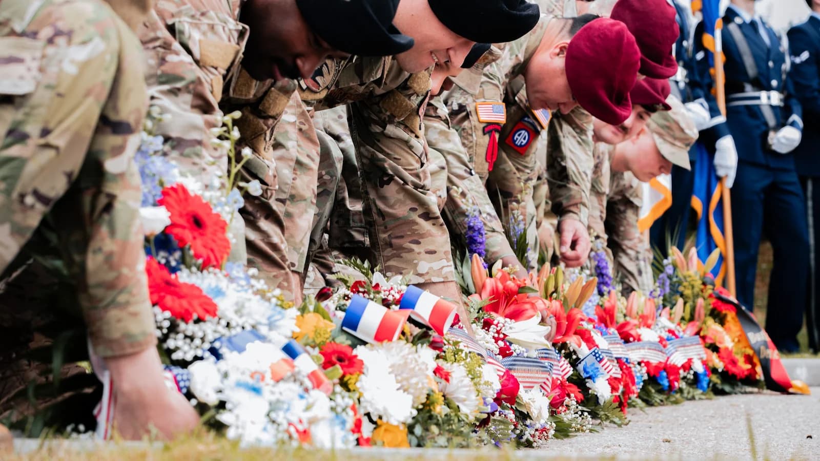 American soldiers paying respects by laying flowers at a D-Day memorial during the 81st anniversary commemoration in Normandy. A solemn ceremony honoring the courage and sacrifice of those who landed on June 6, 1944.