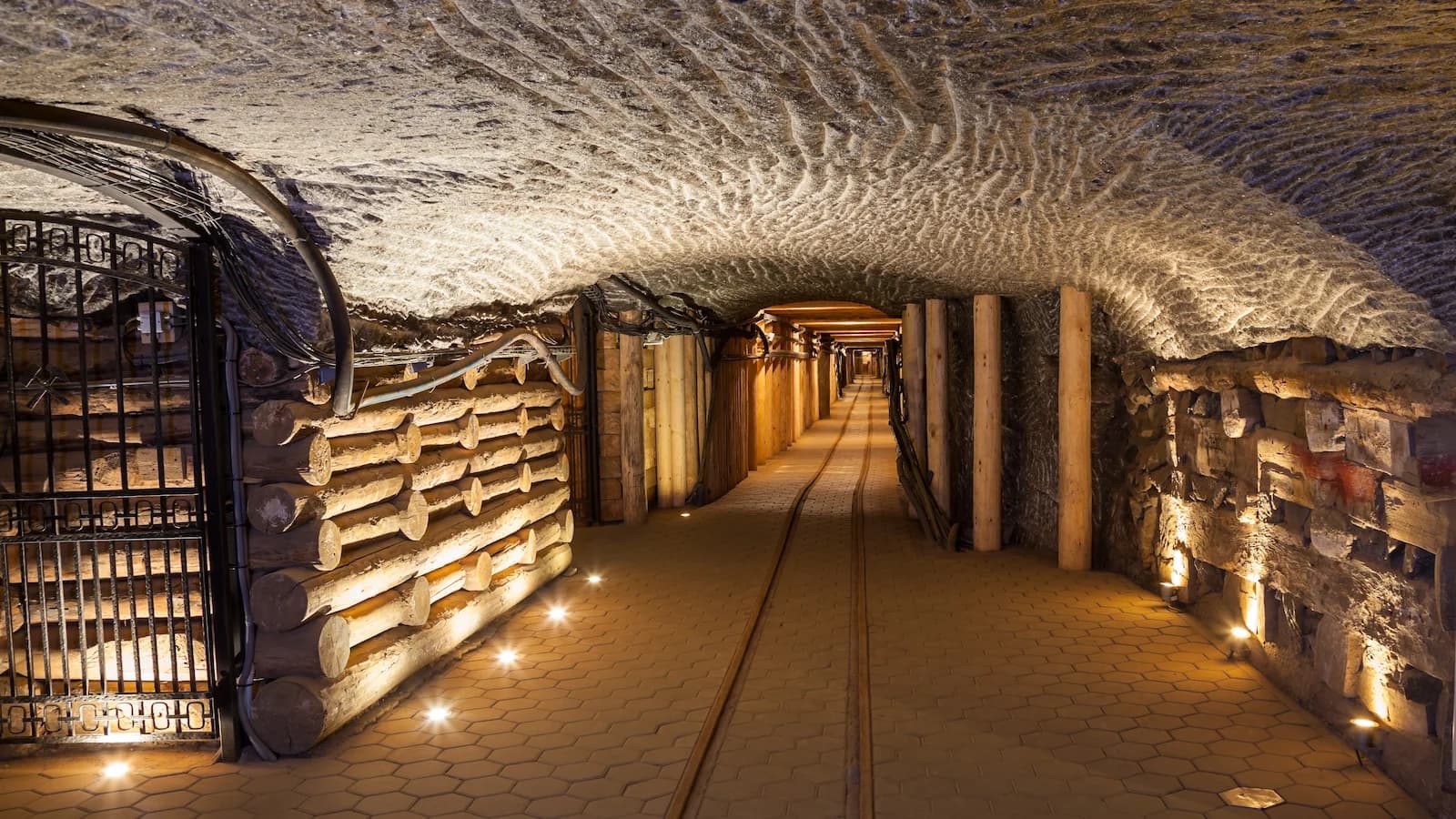 Illuminated historic tunnel inside the Wieliczka Salt Mine near Krakow, a UNESCO World Heritage Site with centuries-old salt carvings, timber supports, and labyrinthine passageways dating back to the 13th century.